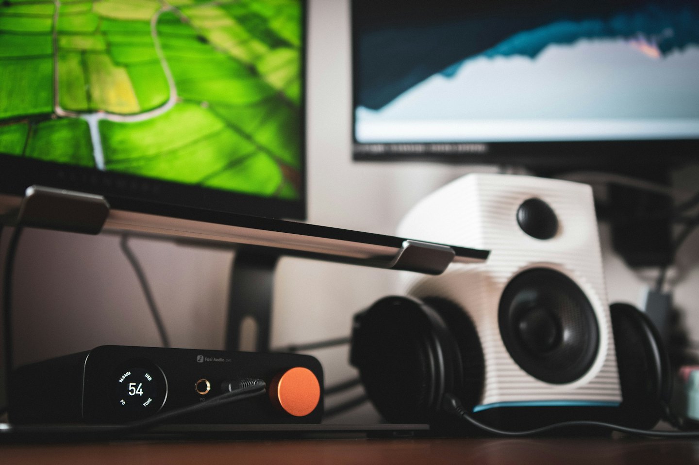 Modern audio equipment sits on a wooden desk.